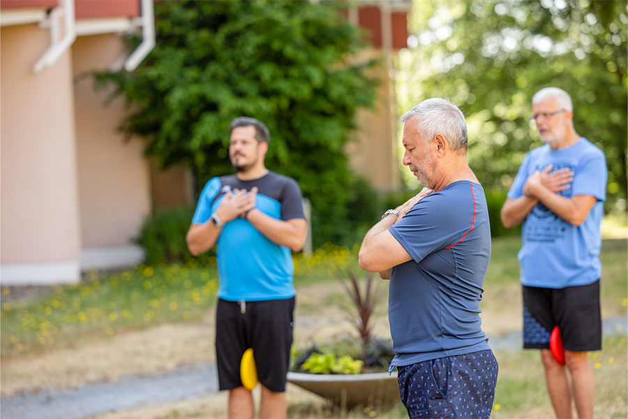 Ein Therapeut leitet zwei Patienten bei Atemübungen an.